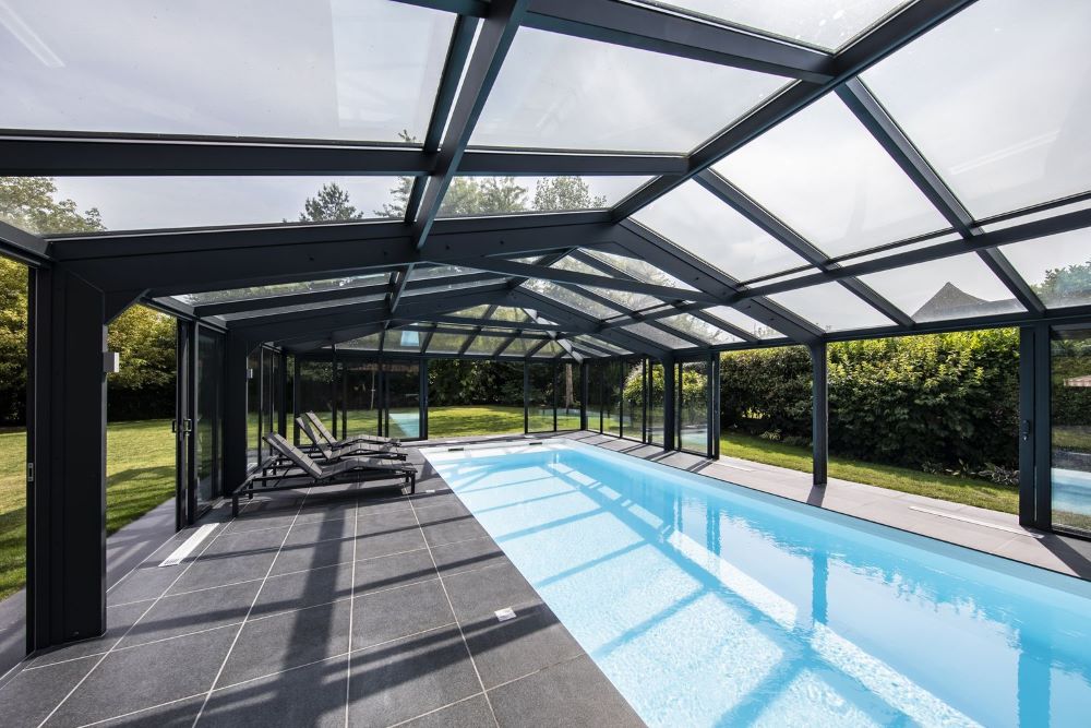 Abri de piscine télescopique en aluminium et polycarbonate installé sur une piscine de jardin