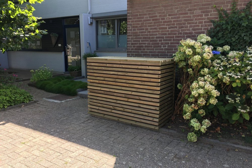 Abri à poubelles en bardage bois adossé à l'entrée d'une propriété, facilitant l'accès à la collecte des déchets