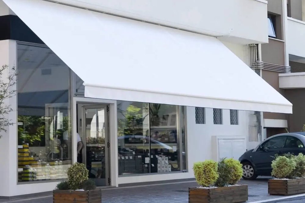 Auvent commercial installé à une hauteur suffisante pour garantir le passage sécurisé des piétons sur le trottoir