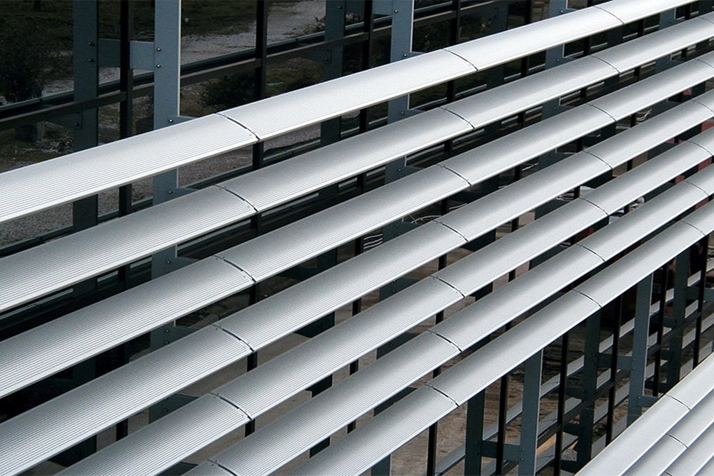 Détail technique d'un coffre de brise-soleil orientable posé en sous-face de linteau avec coulisses en aluminium