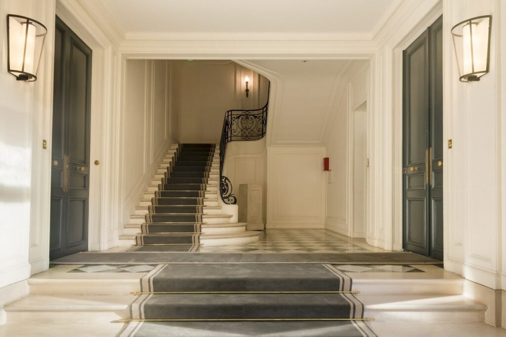 Cage d'escalier d'un immeuble en copropriété en cours de rénovation avec nouveau garde-corps et peinture