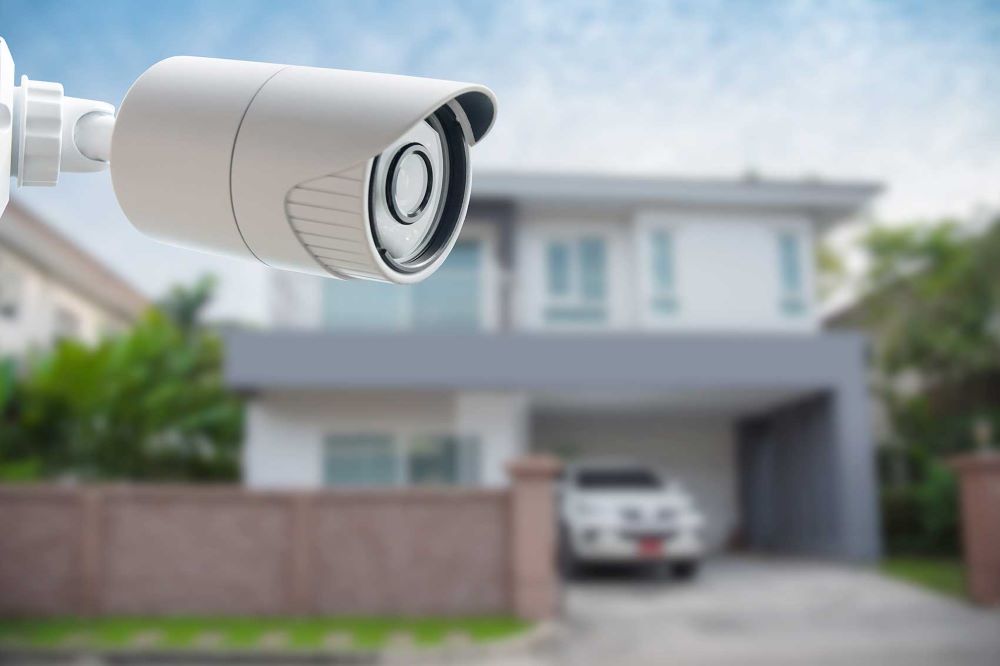 Caméra de vidéosurveillance installée à l'entrée d'une maison individuelle filmant la propriété privée