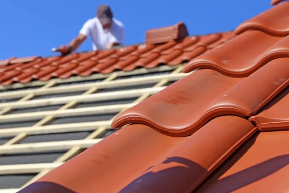 Chantier de rénovation de toiture en cours respectant les prescriptions de teintes et de matériaux exigées par la mairie