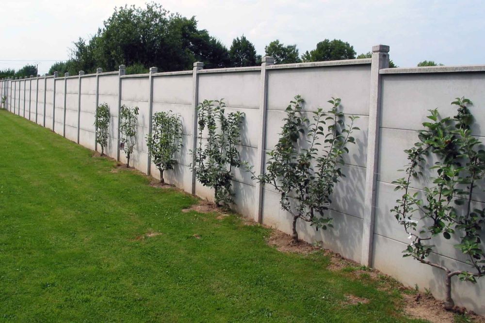 Mur mitoyen entre deux jardins de maisons avec chaperon penché indiquant la propriété