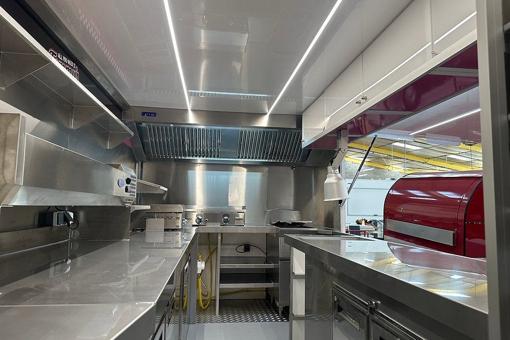 Cuisine intérieure d'un food truck équipée de matériel de conservation et de cuisson conforme aux normes sanitaires