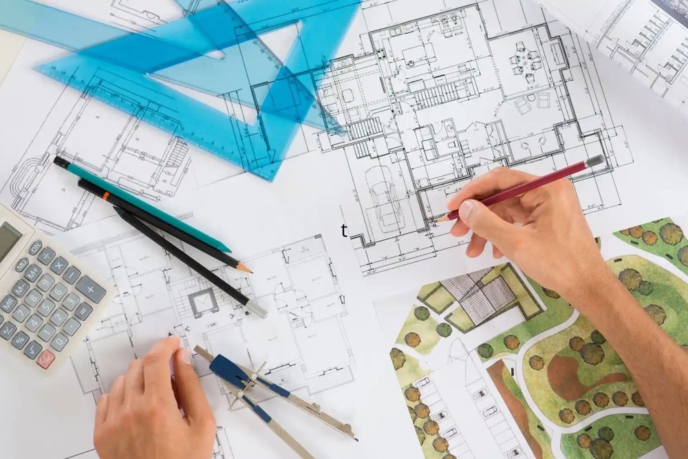 Dessinateur ajustant des plans techniques de façade pour une déclaration préalable modificative en cours de chantier