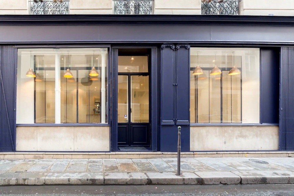 Façade d'un ancien commerce réorganisée avec le maintien d'une vitrine ou d'une séparation claire entre local et partie privative
