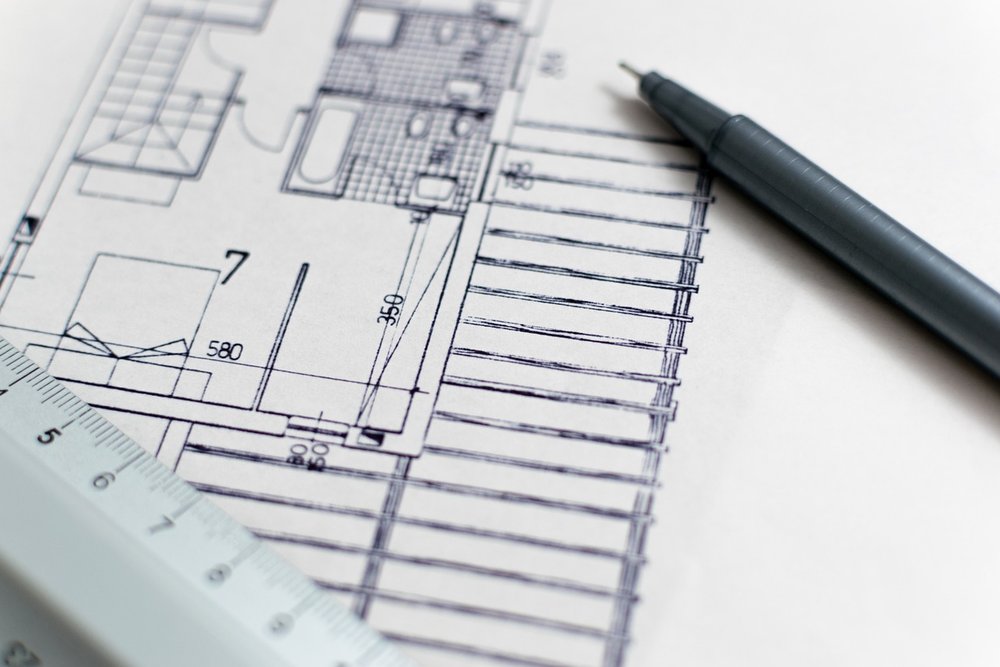 Dessinateur en bâtiment travaillant sur les plans de masse et de façade d'une maison individuelle pour une régularisation