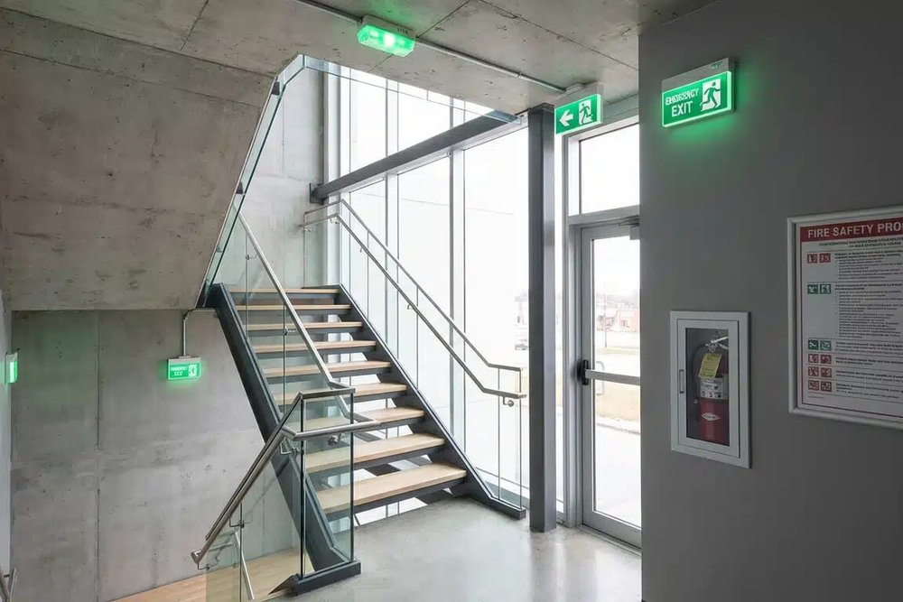 Éclairage de sécurité installé dans une cage d'escalier d'immeuble garantissant l'évacuation en cas d'incendie