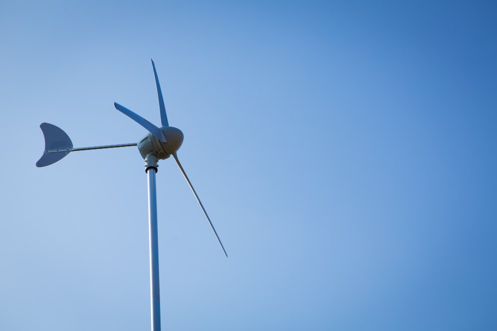 Éolienne domestique installée sur un mât autonome dans le jardin d'une propriété individuelle