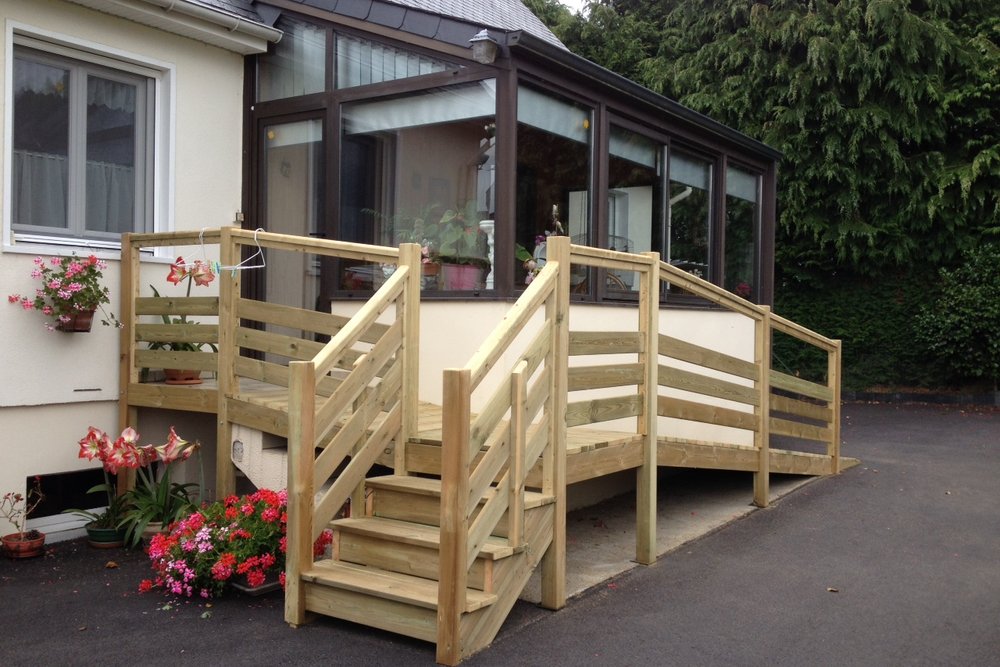 Escalier extérieur et rampe d'accès PMR menant à l'entrée d'une maison individuelle