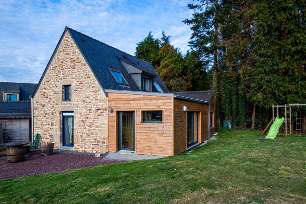 Extension en ossature bois accolée à une maison ancienne en pierre, solution légère adaptée aux fondations existantes