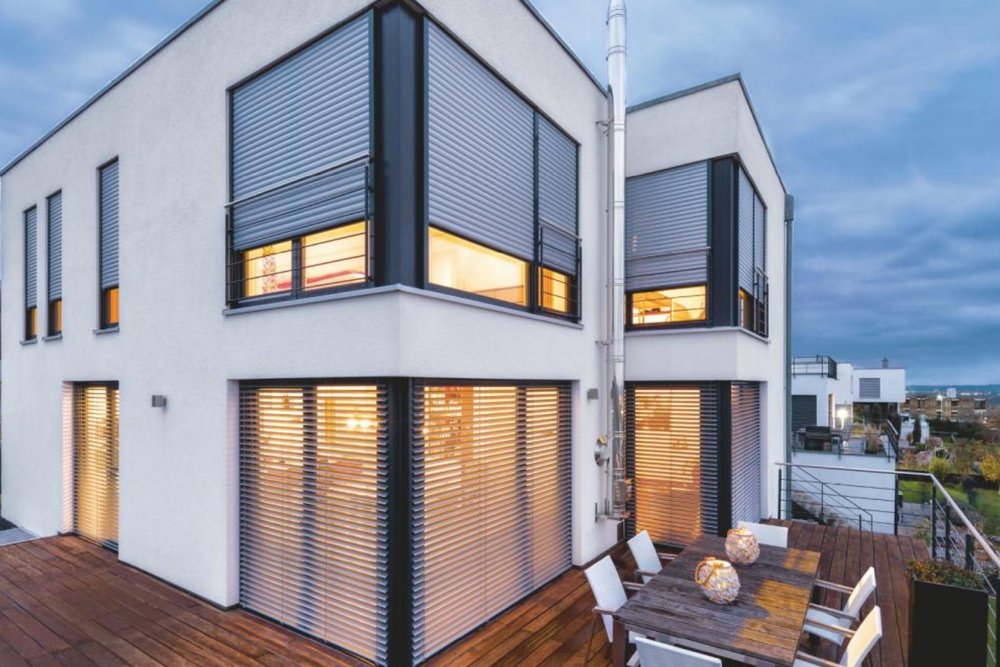 Façade d'une maison contemporaine équipée de brise-soleil orientables en aluminium thermolaqué