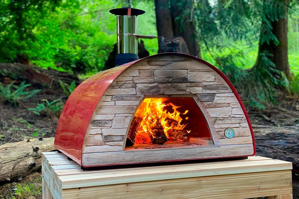 Four à bois fixe intégré à une cuisine d'été extérieure, respectant des distances de sécurité par rapport aux éléments combustibles