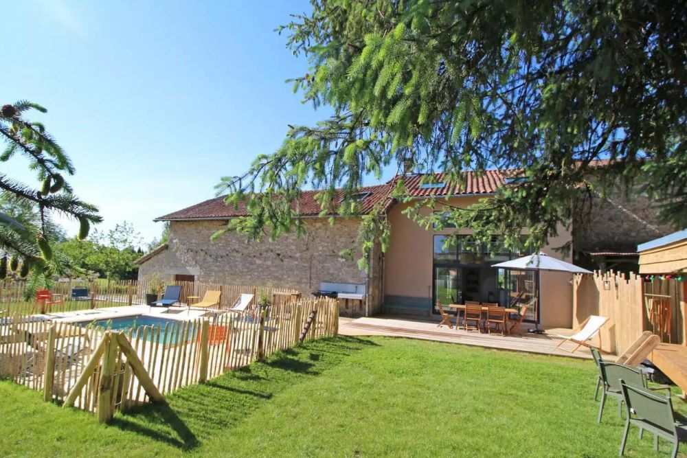 Gîte rural en pierre avec jardin fleuri dans un village français illustrant la création d'un hébergement touristique