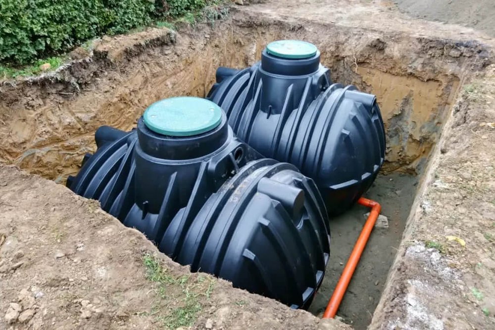Travaux de terrassement pour l'installation d'une cuve enterrée de récupération d'eau de pluie dans un jardin résidentiel