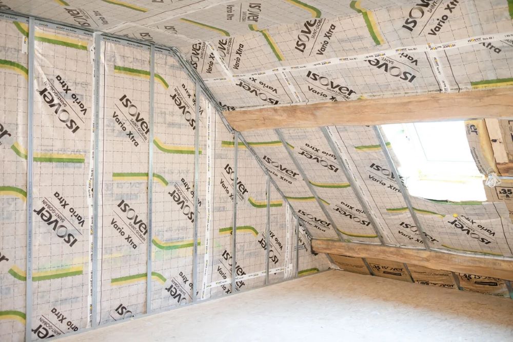 Pose d'un pare-vapeur sur l'isolant lors d'une isolation thermique par l'intérieur avant fermeture par plaques de plâtre