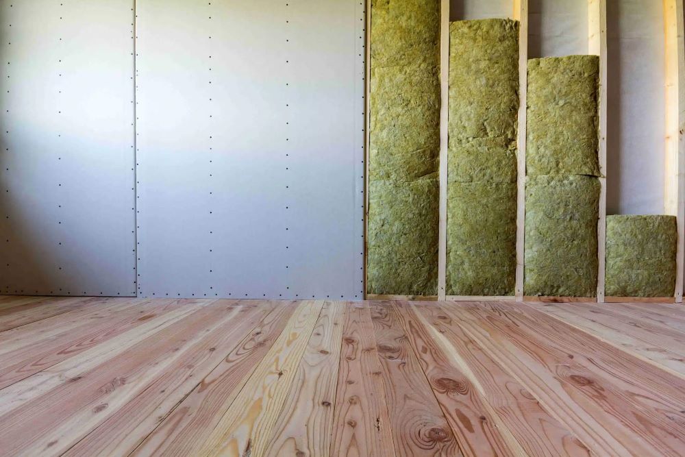 Travaux d'isolation phonique dans un appartement avec pose de rails et laine acoustique sur une paroi séparative
