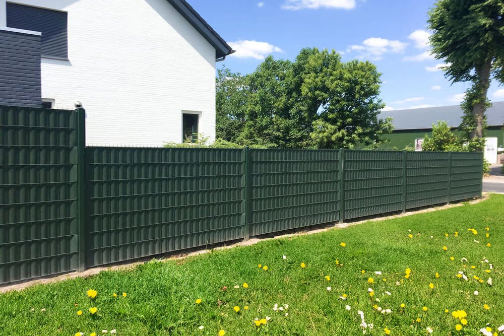 Jardin familial avec espace de jeux pour enfants aménagé à distance raisonnable de la clôture du voisin