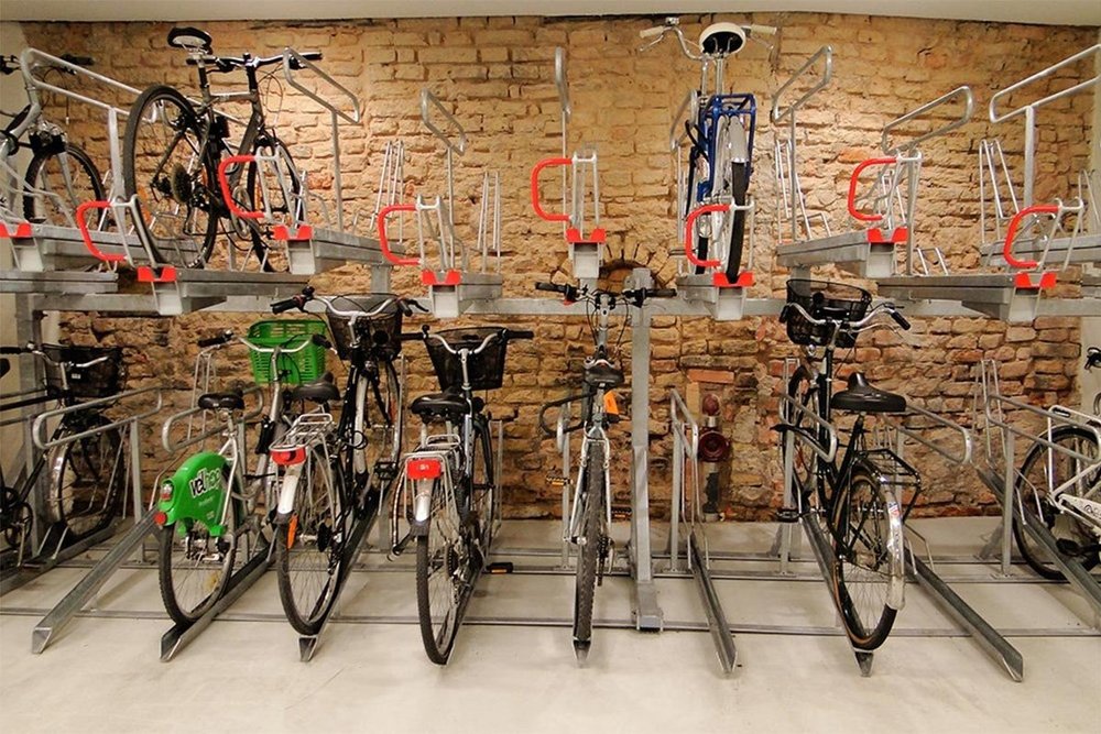 Local à vélo sécurisé aménagé en rez-de-chaussée d'un immeuble collectif neuf, équipé d'arceaux de stationnement