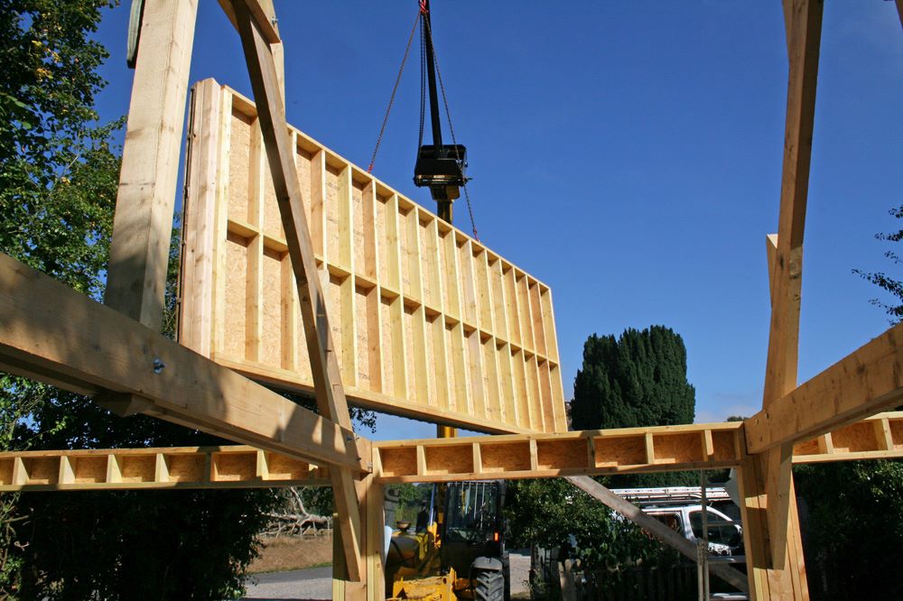 Maison individuelle préfabriquée hors site posée sur des fondations avec grue lors de l'assemblage sur le terrain