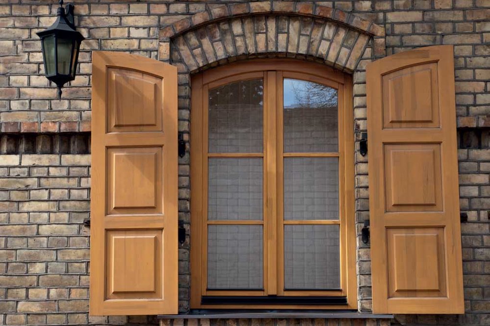 Fenêtre traditionnelle en bois avec petits bois et imposte en façade ancienne nécessitant une reproduction exacte pour être dispensée de déclaration