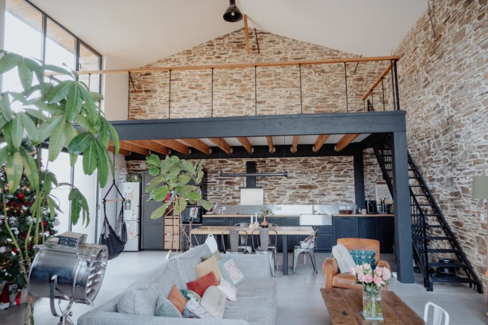 Mezzanine avec bureau aménagé dans un loft à grande hauteur sous plafond avec escalier en métal