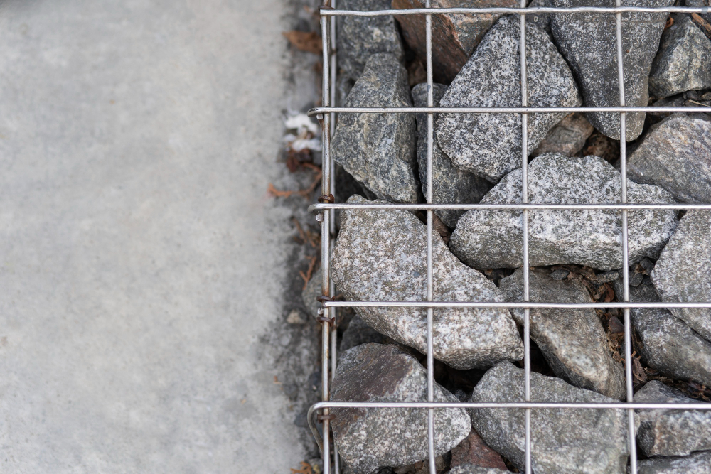 Mur de soutènement en gabions remplis de pierres dans un jardin en pente