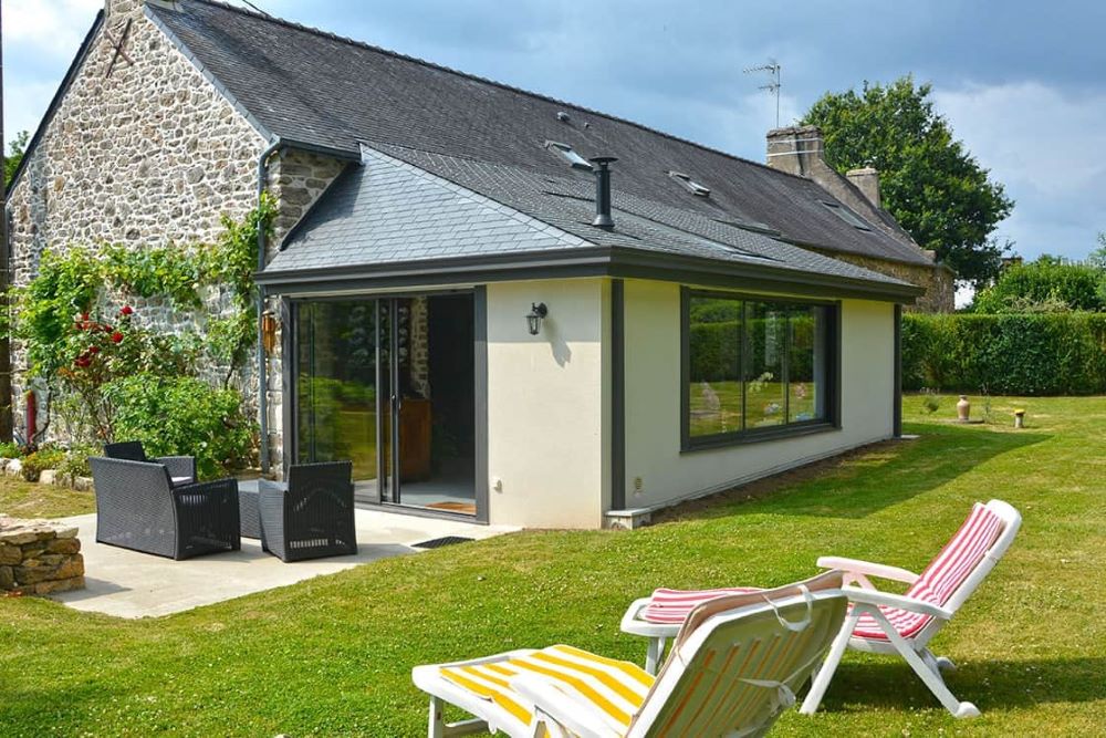 Extension de maison avec matériaux cohérents avec la construction existante illustrant le contenu d'une notice descriptive