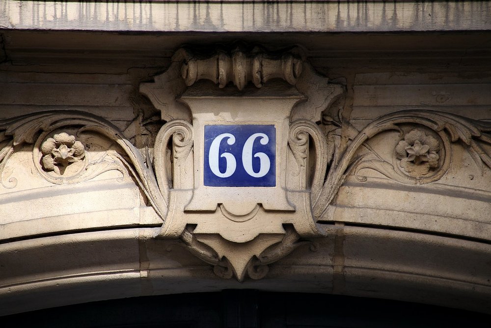 Plaque de numéro de rue installée sur la façade d'une maison neuve, adresse officiellement attribuée par la mairie