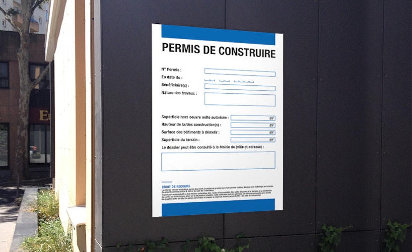 Panneau de chantier réglementaire affiché sur un terrain avec permis de construire obtenu