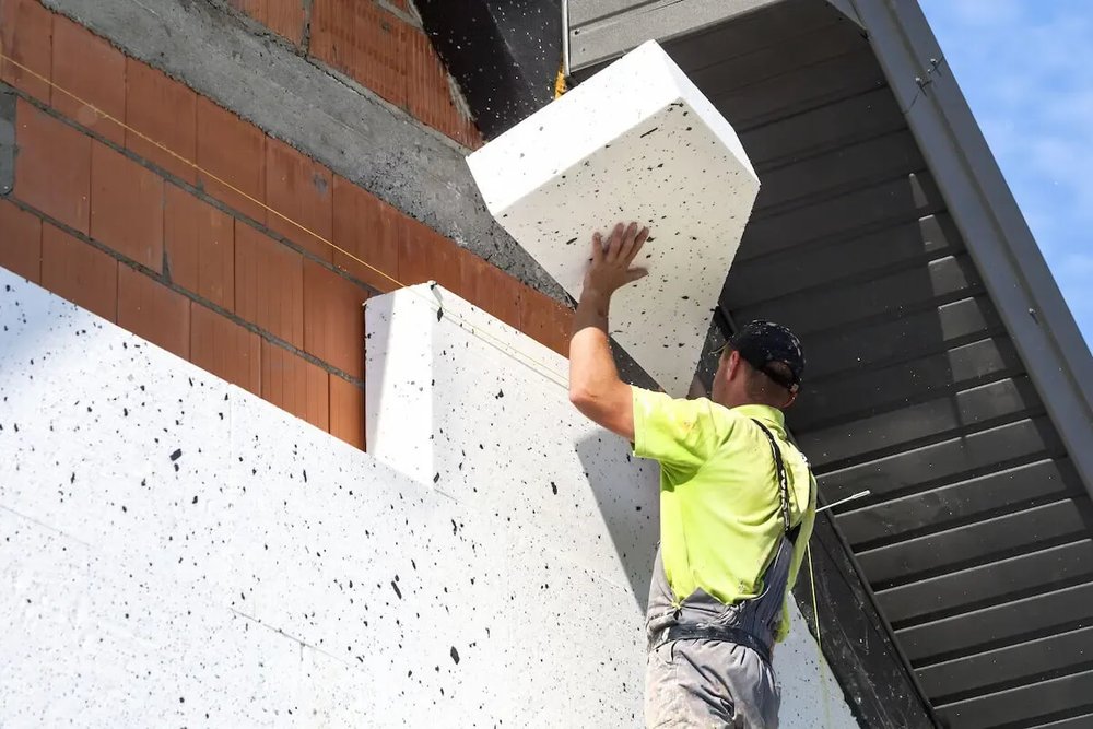 Panneaux isolants posés sur la façade d'un immeuble collectif dans le cadre d'une rénovation énergétique