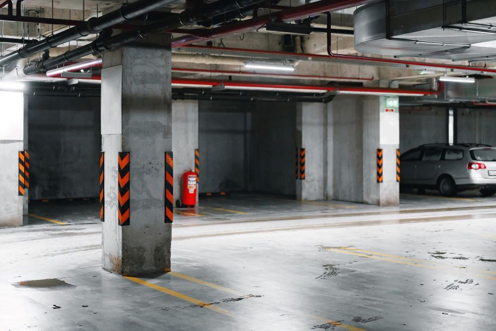 Parking souterrain commun d'un immeuble collectif avec places de stationnement réglementaires et place PMR