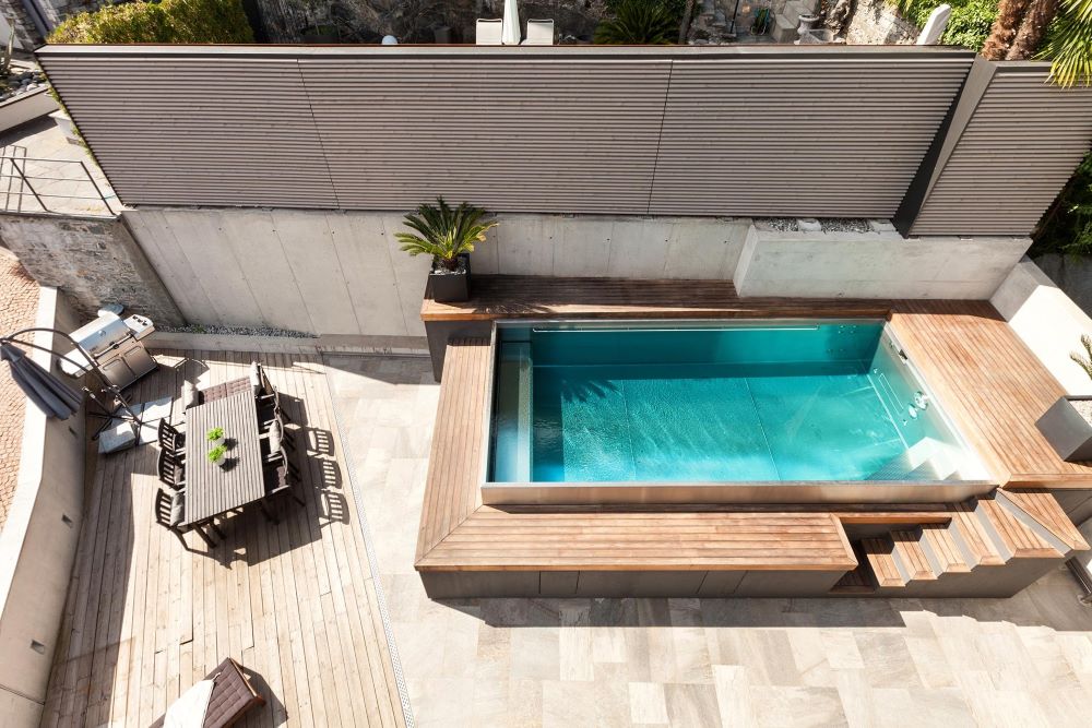 Piscine hors-sol en bois avec terrasse périphérique dans un jardin de maison individuelle