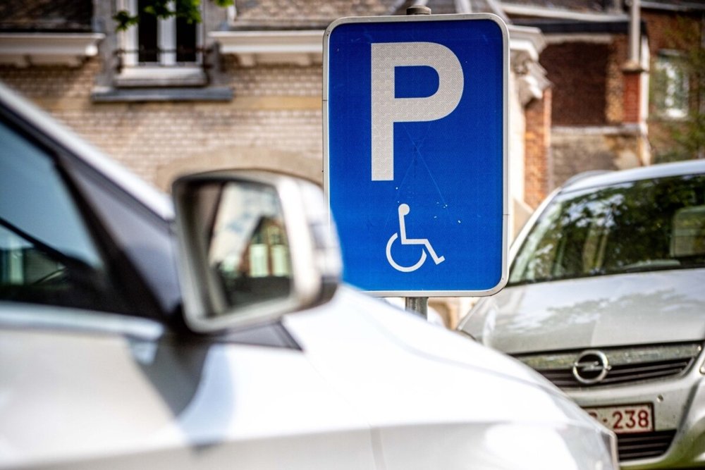 Place de stationnement PMR marquée au sol avec pictogramme et panneau vertical dans un parking commercial