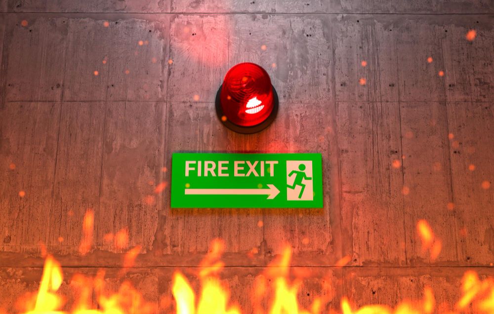 Plan d'évacuation incendie affiché dans un commerce ERP avec sorties de secours et extincteurs
