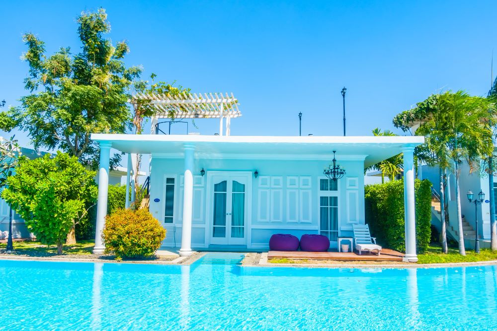 Pool house en bois avec local technique et espace de repos au bord d'une piscine enterrée