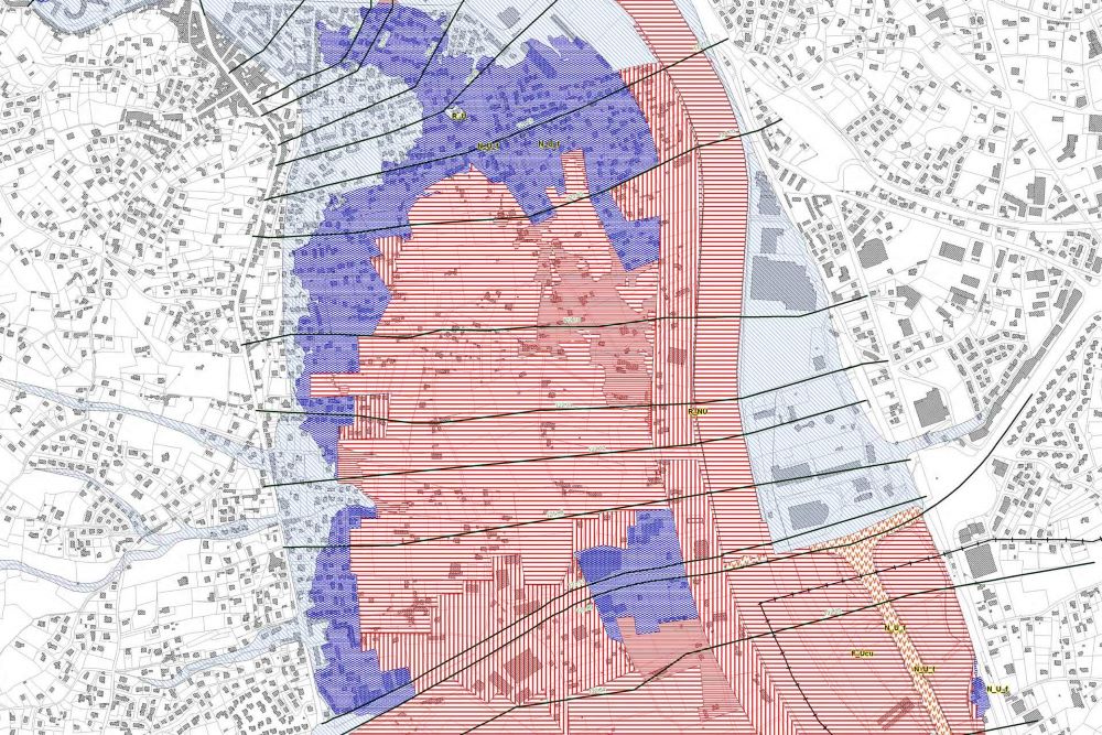 Carte de zonage d'un PPRI montrant les zones bleues et rouges le long d'un cours d'eau avec les règles de construction applicables