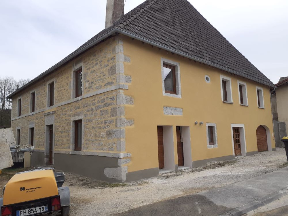 Façade de maison ancienne ravalée à l'enduit à la chaux teinté dans les tons ocre conformes aux prescriptions de l'ABF