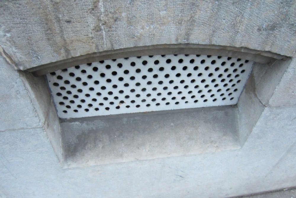 Petit soupirail assurant la ventilation d'une cave, distinct d'une cour anglaise permettant une véritable fenêtre praticable