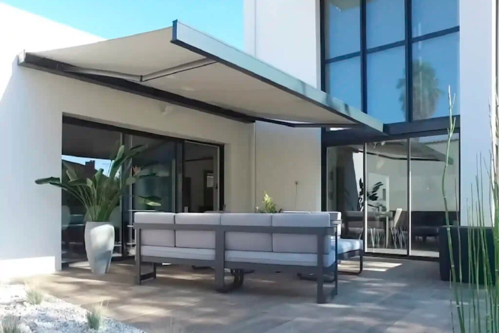 Store banne déployé sur la façade d'une maison individuelle, protégeant la terrasse du soleil