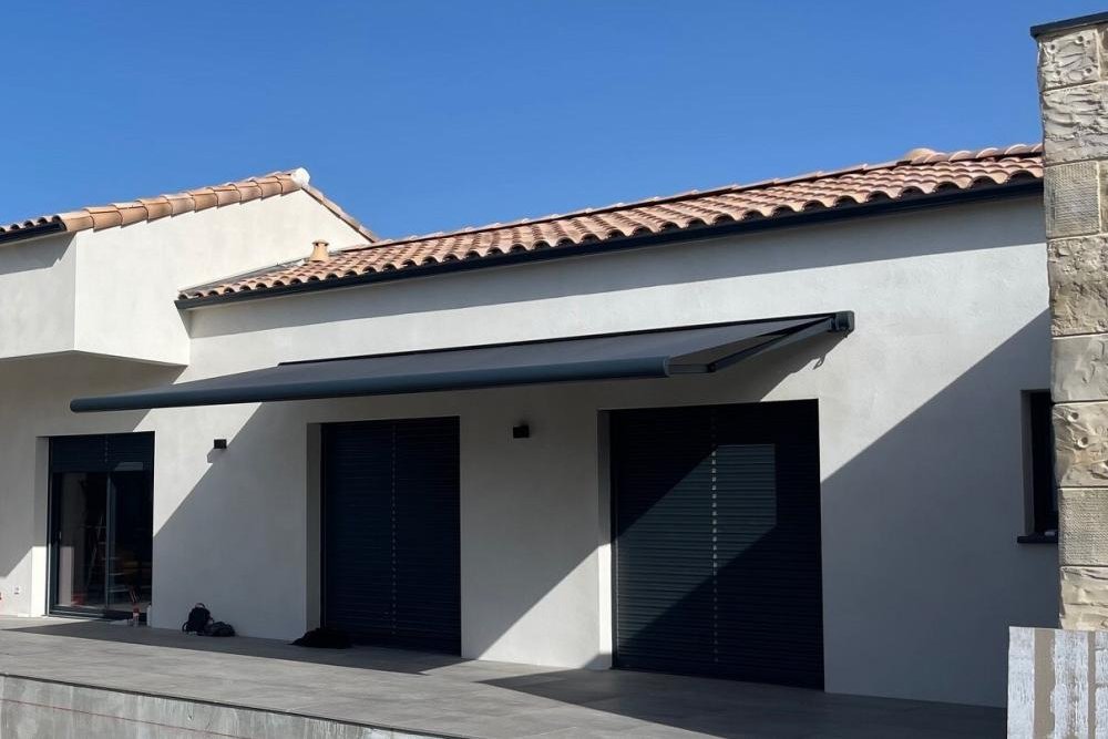 Store banne de couleur sobre installé sur une façade en secteur protégé, conforme aux prescriptions de l'Architecte des Bâtiments de France