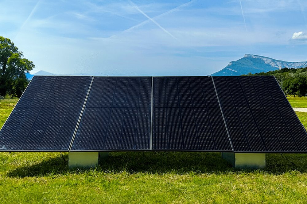 Structure inclinée de panneaux photovoltaïques installée au sol, distincte du régime applicable à une pose en toiture