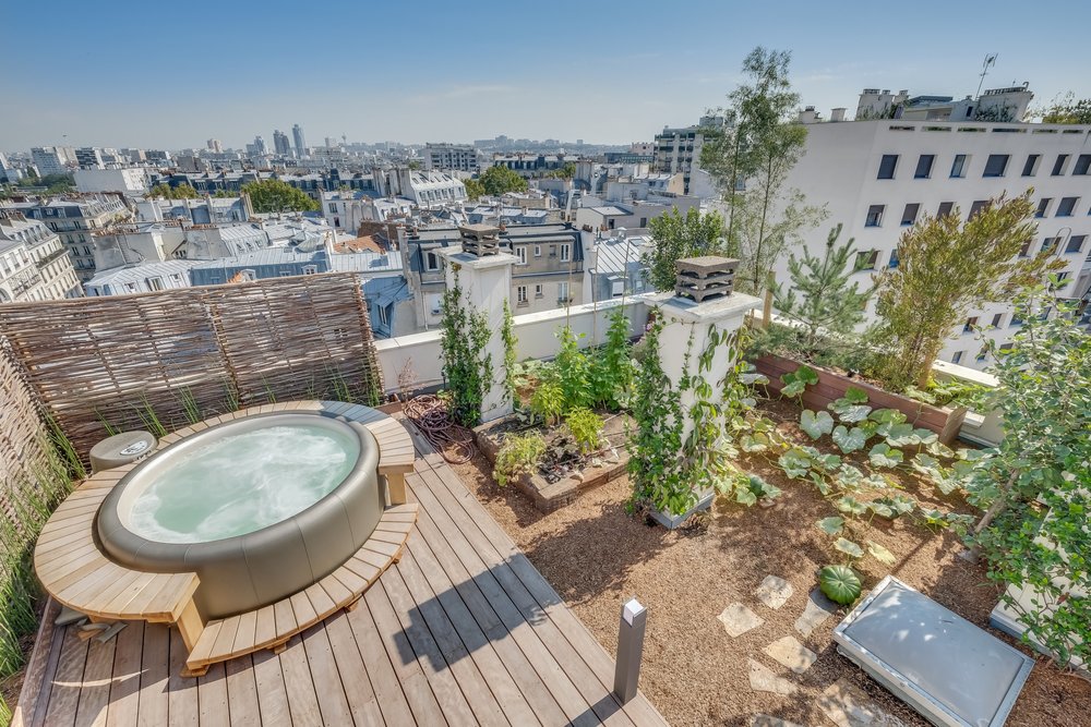 Terrasse accessible aménagée sur une toiture plate en milieu urbain, offrant un espace extérieur supplémentaire