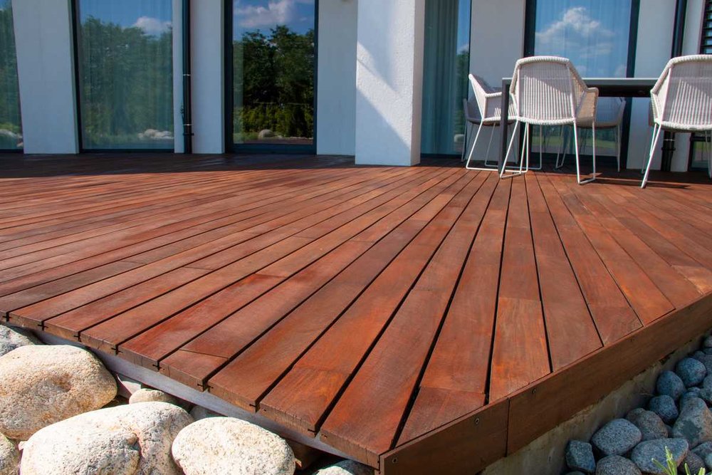 Terrasse en bois installée sur plots réglables dans le jardin d'une maison individuelle