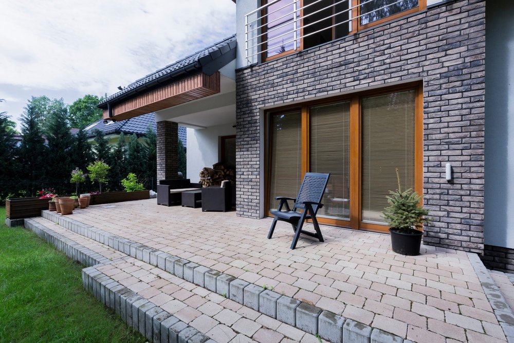 Chantier d'une terrasse extérieure surélevée sur plots et maçonnerie modifiant le relief du jardin