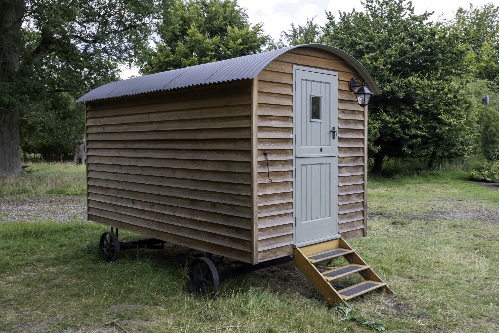 Tiny house sur roues avec bardage bois installée dans un cadre champêtre
