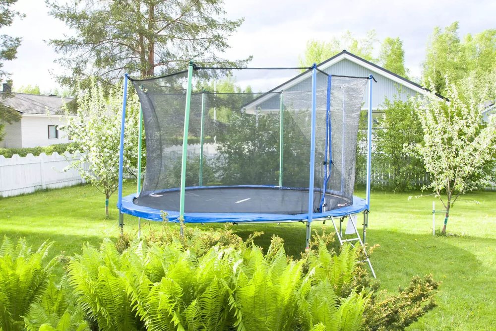 Trampoline installé dans un jardin résidentiel, équipement de loisirs non ancré au sol