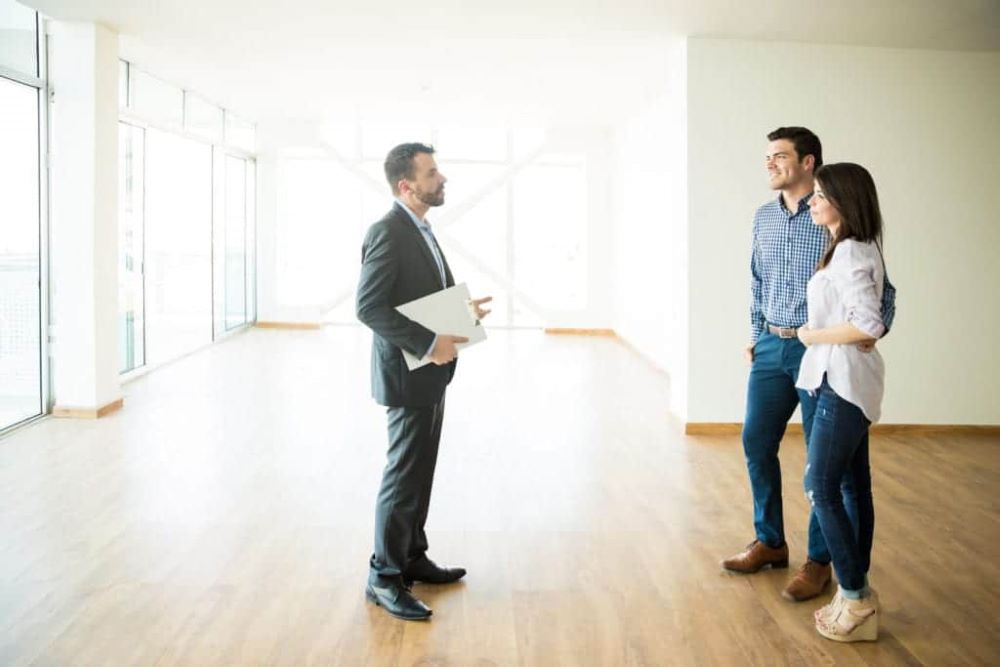Visite de livraison d'un appartement neuf en VEFA avec acheteur et promoteur notant les réserves sur le procès-verbal