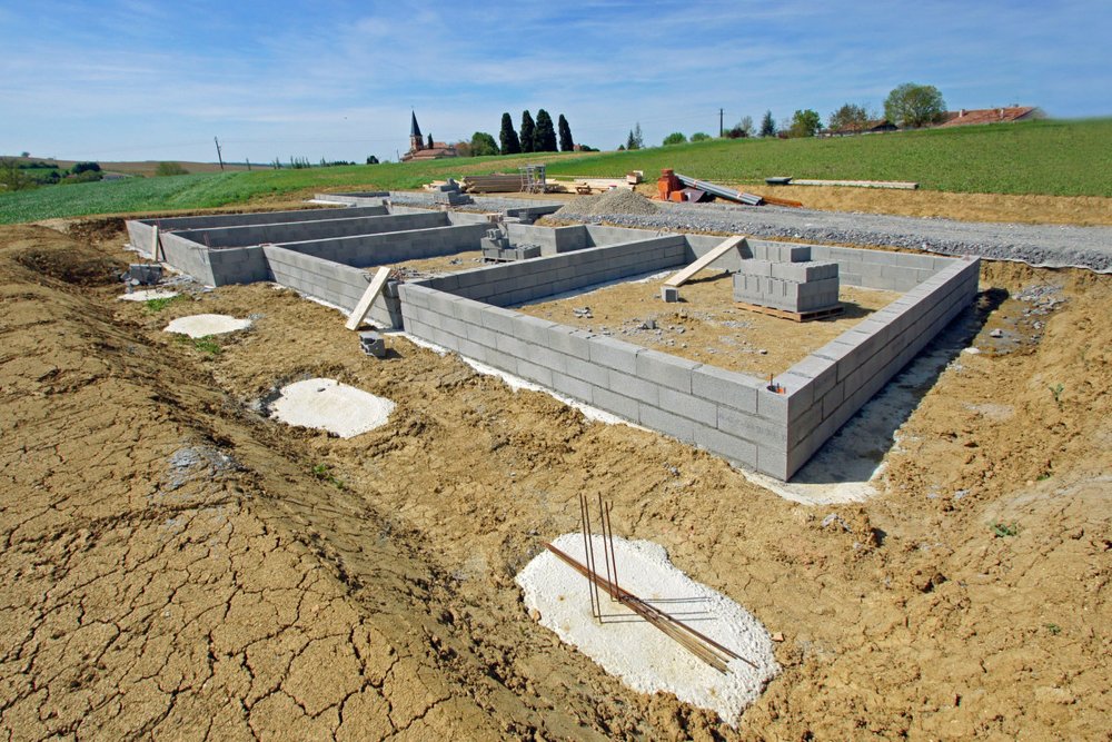 Vide sanitaire sous une maison individuelle montrant les murs de soubassement, les grilles de ventilation et l'espace entre le sol et le plancher bas